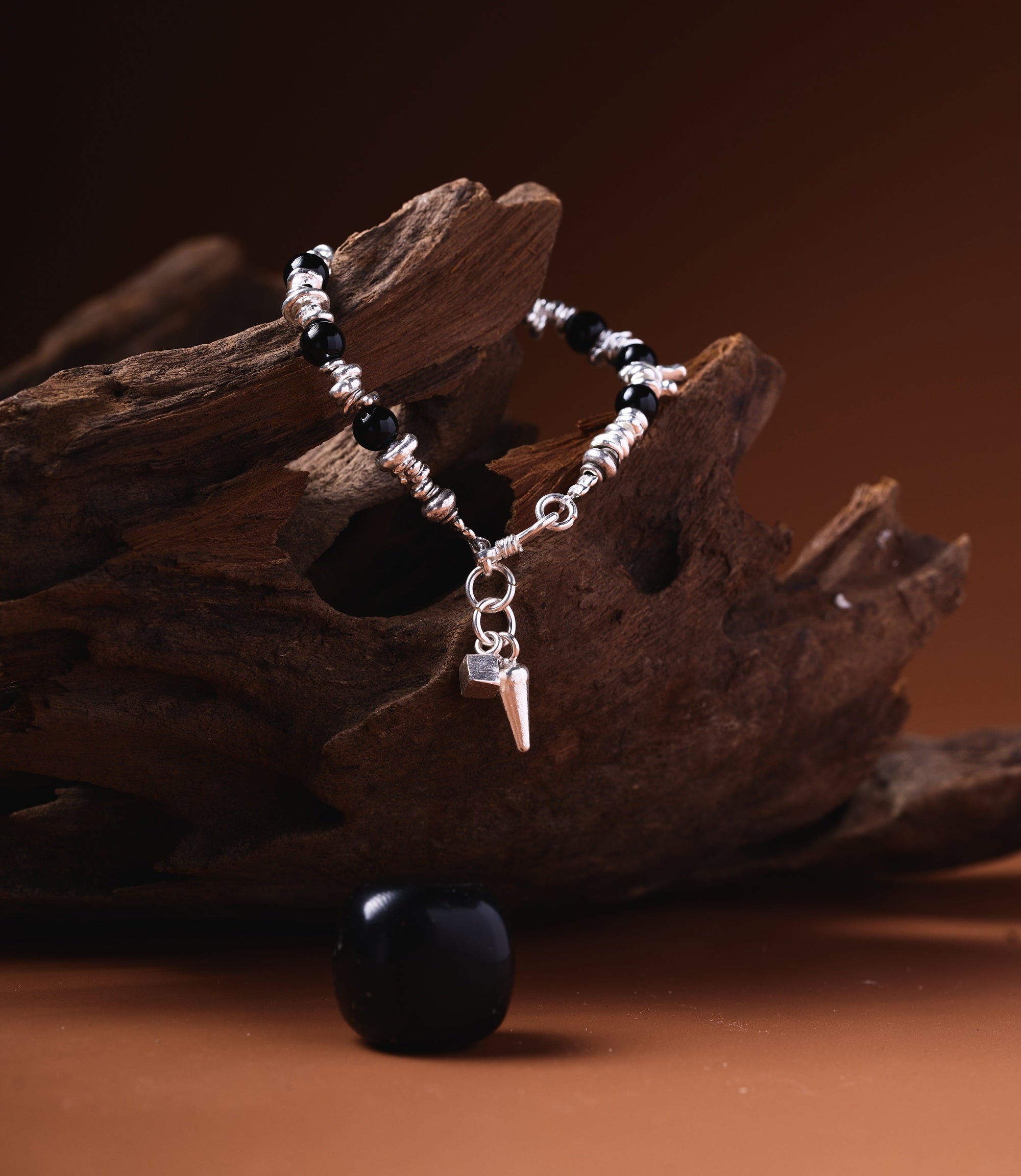 Raven Onyx Charm Bracelet handcrafted with black Onyx beads, pure silver beads, and a silver spike charm