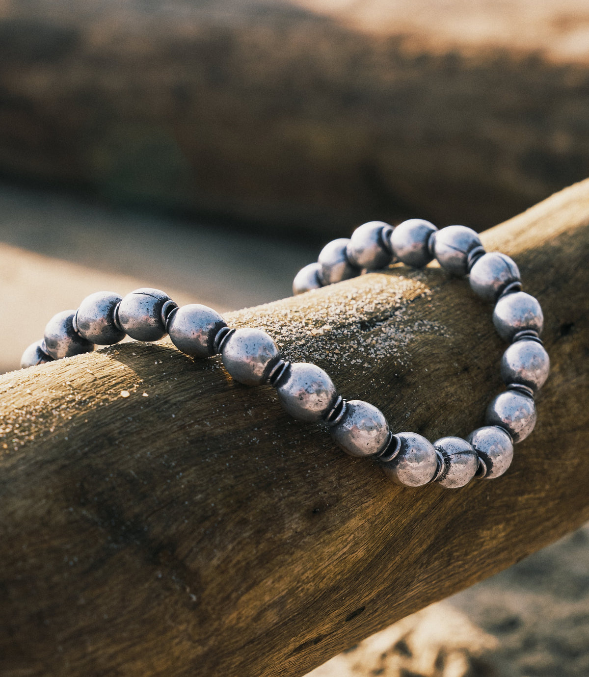 Zuma Necklace in pure silver featuring chunky hand-polished beads with ridged spacers, laid flat on a neutral surface