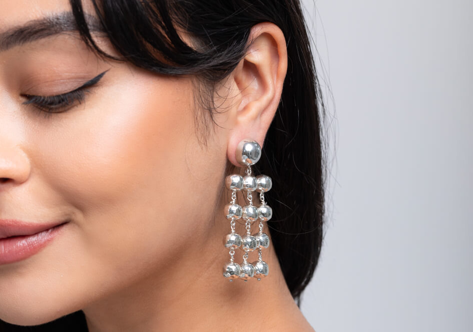 Model wearing Theresa Chandelier Earrings, a bold festive 925 sterling silver chandelier earring for everyday and occasion styling.
