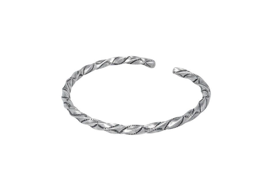 Twisted bangle with fine stamped details from Hill to Street over a white background