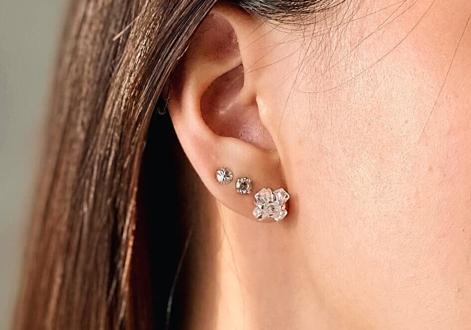 Zoomed-in photo of a model wearing a pair of X Cubic Zirconia stud earrings from Hill to Street