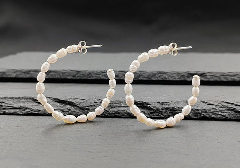 Pair of pearl hoop earrings from Hill to Street over black background