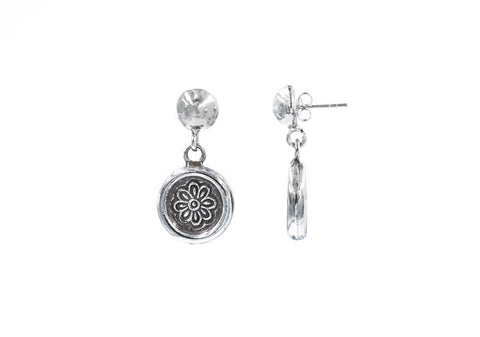 Pair of silver studs with drop-down flower stamped circle over a white background