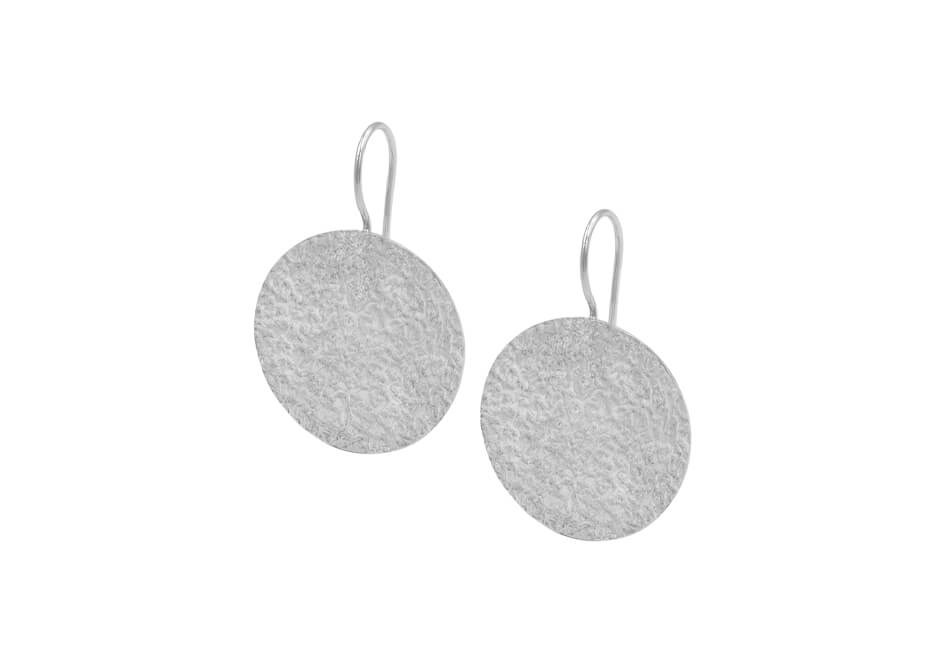 Pair of textured sterling silver disc drop earrings from Hill to Street over a white background