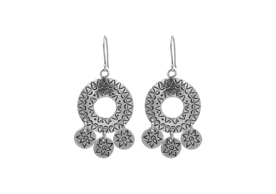 Pair of tribal circle silver drop earrings over a white background