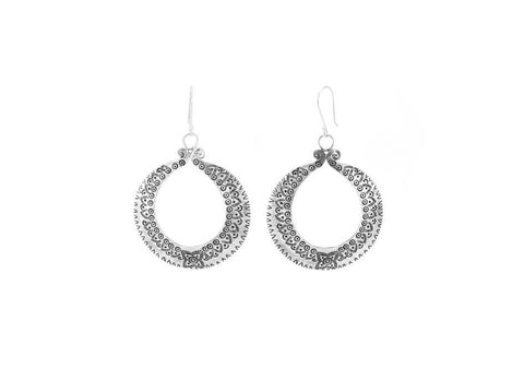 Pair of tribal statement circular silver earrings over white background